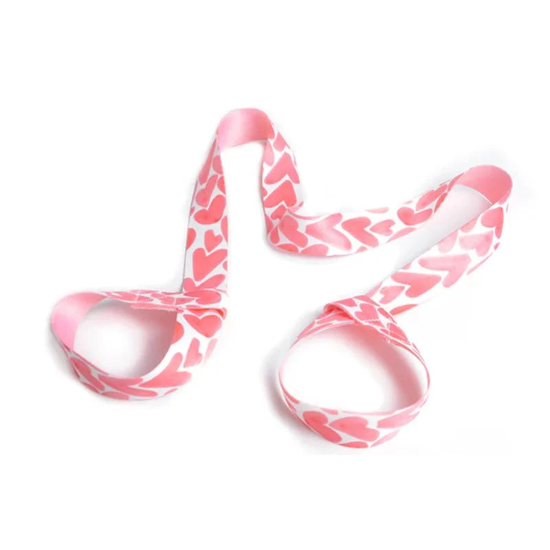 "Pink heart-patterned adjustable yoga mat strap with looped ends for secure mat transport. Stylish and functional for yoga lovers and fitness fans."