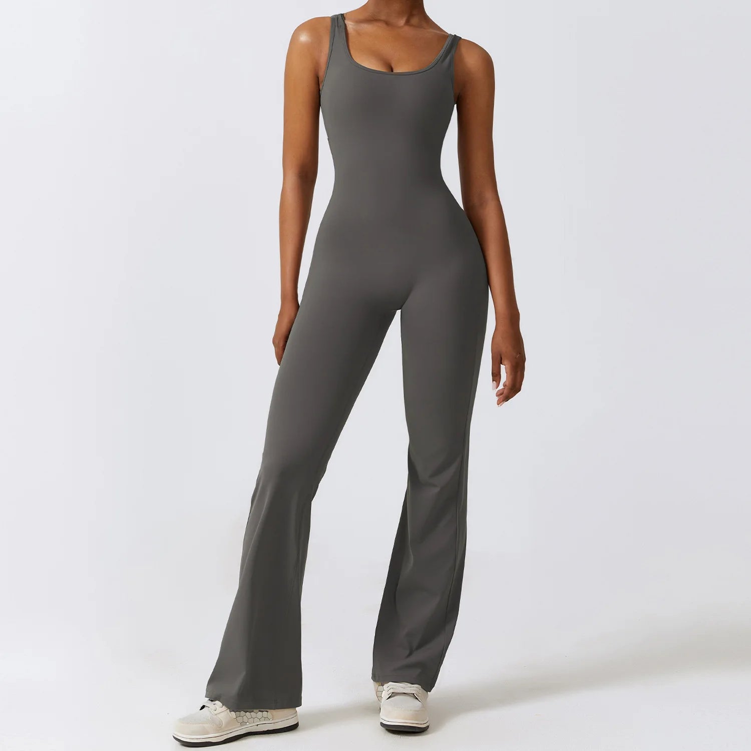 Person wearing a gray jumpsuit on a white background