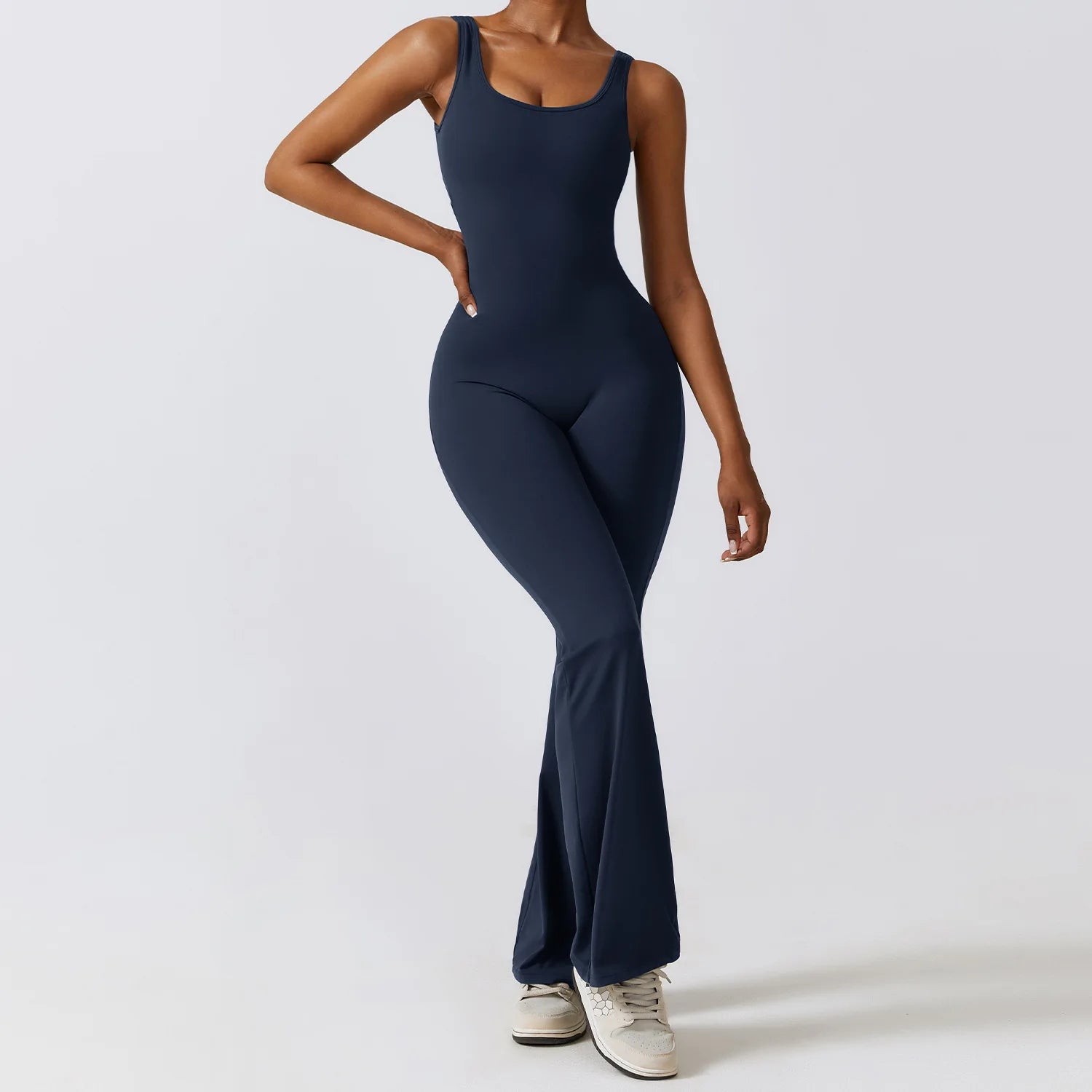 Person wearing a navy blue jumpsuit on a white background