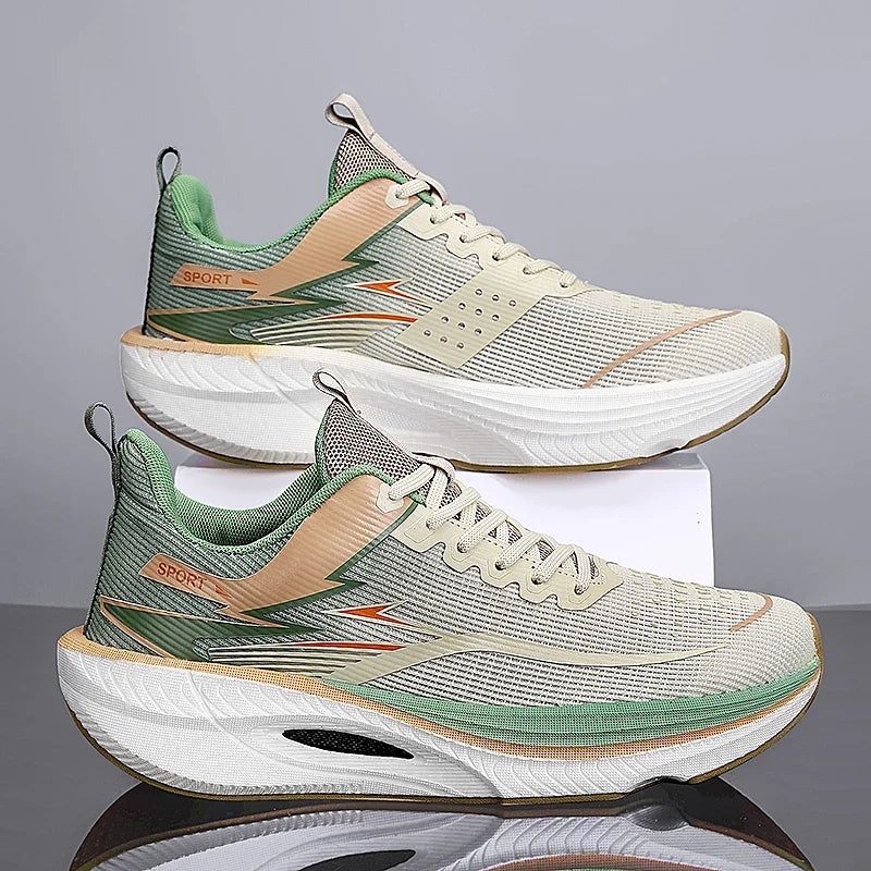 A pair of athletic running shoes stacked on a white display block against a gray studio background. The shoes feature a light beige mesh upper with green and peach accents, a thick white midsole, and a reflective surface below.