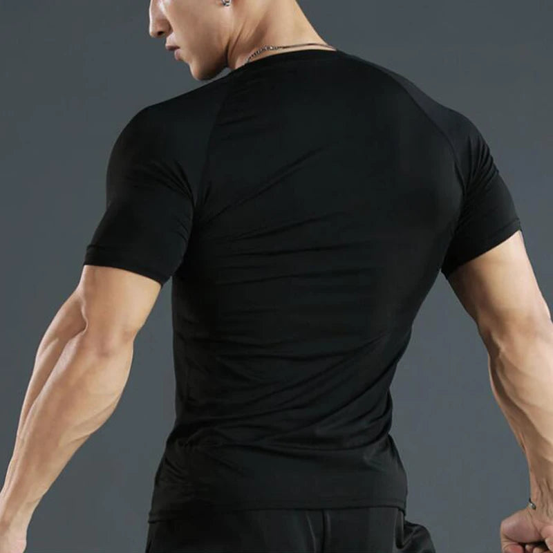 Man wearing a black t-shirt against a gray background