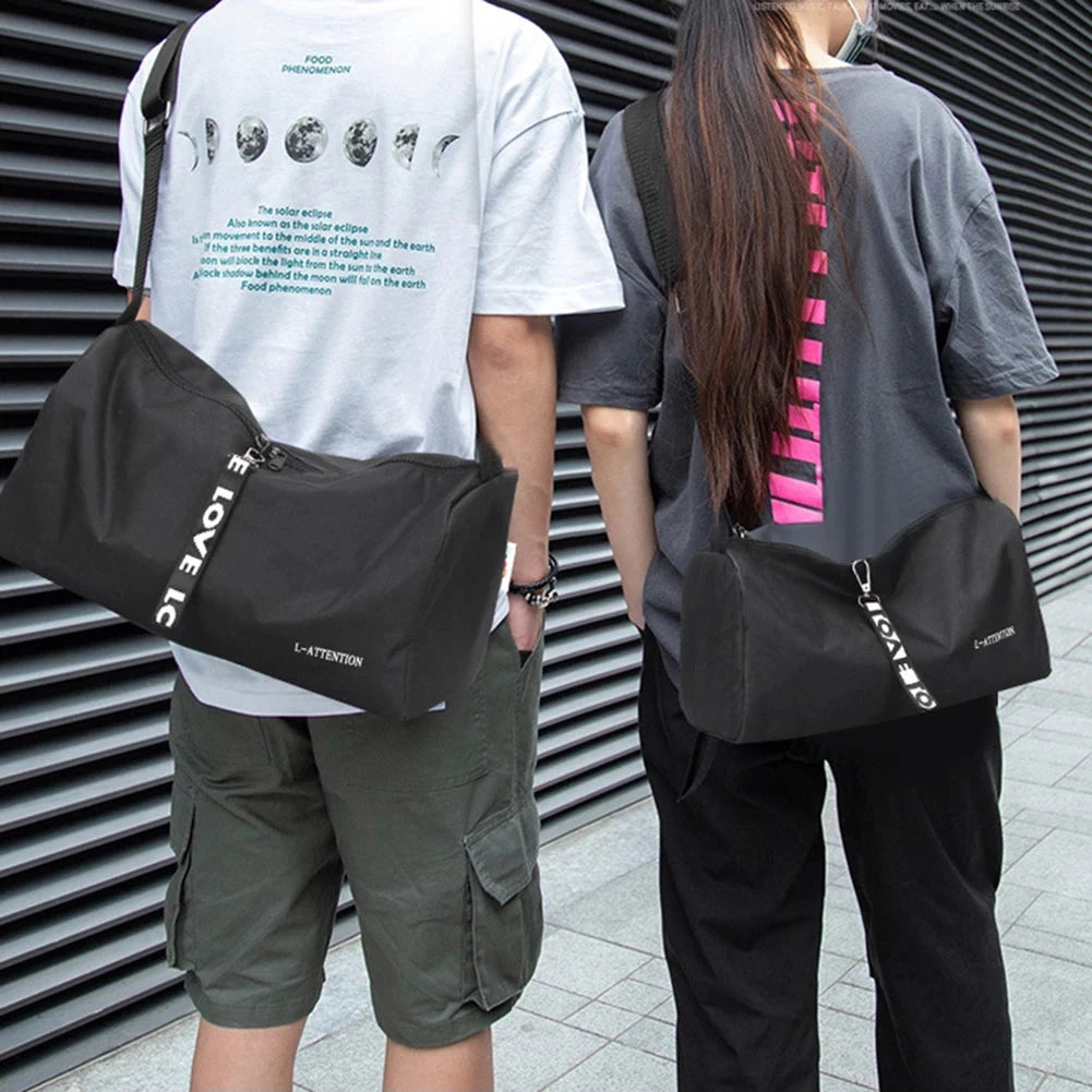 Two people wearing black fitness gym bags across their shoulders, demonstrating the bag's unisex and portable design.