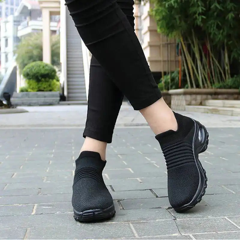 Women Sneakers Fashion Breathable Walking Mesh Platform Shoes in black with slip-on design and cushioned sole for gym or casual wear.